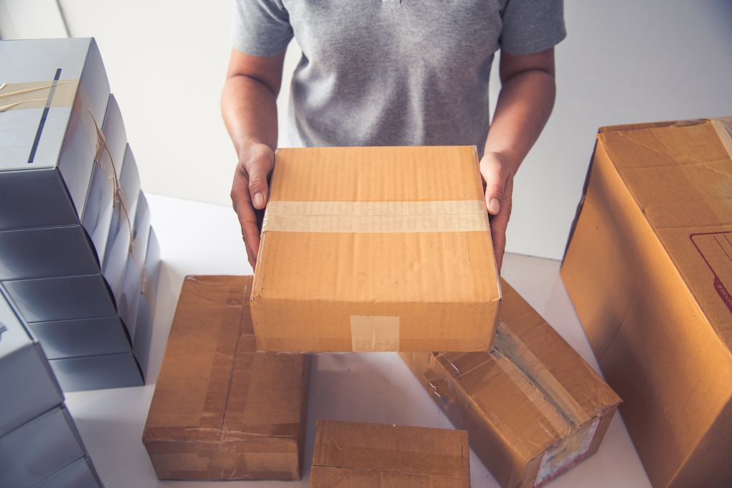 a person arranging boxes for shipment