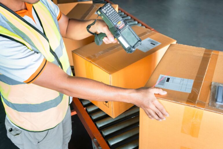 delivery personnel scanning packages on a conveyor