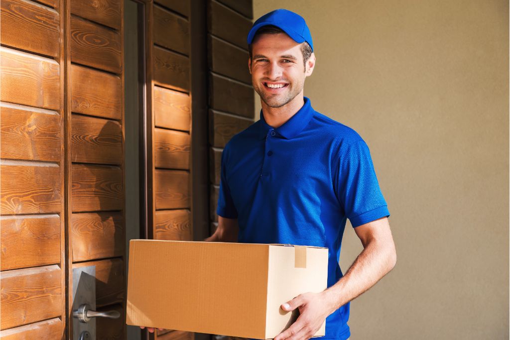 Delivery man carrying package at the door outside a house