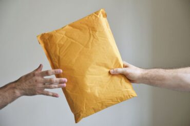 hand passing a parcel to another hand