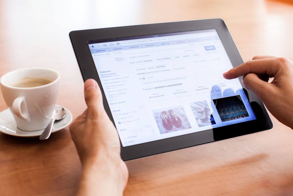 a hands holding a tablet showing a online shopping application